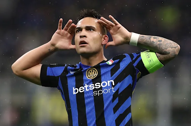 Pemain Inter Milan merayakan gol dengan kedua tangan di belakang telinga, menunjukkan kegembiraan.