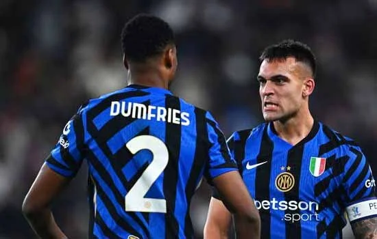 Dua pemain Inter Milan sedang merayakan gol di lapangan dengan suasana pertandingan yang intens.”