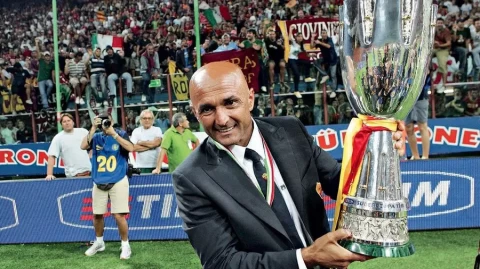 Luciano Spalletti tersenyum sambil mengangkat trofi liga italy