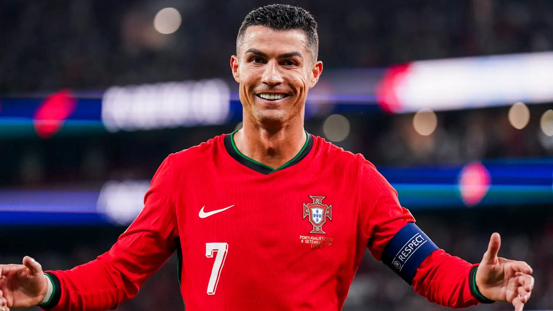 Cristiano Ronaldo, mengenakan jersey merah Portugal, merayakan gol dengan ekspresi fokus dan tangan mengacungkan jempol di lapangan.