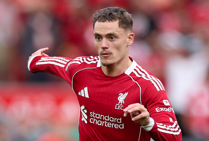 Florian Wirtz, pemain Liverpool, mengenakan jersey merah, ekspresi fokus, di lapangan sepak bola