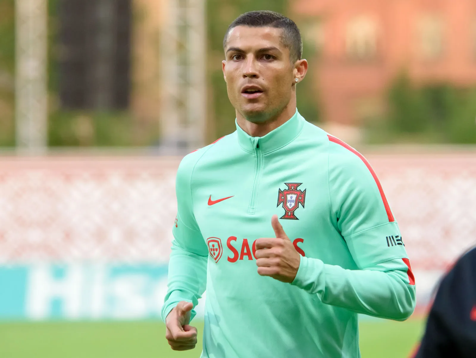 Seorang pemain sepak bola Timnas Portugal sedang menjalani sesi latihan mengenakan jaket latihan berwarna hijau.