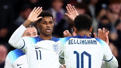 Para pemain tim sepak bola merayakan gol bersama di lapangan