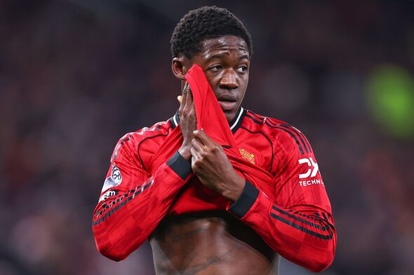 Kobbie Mainoo mengenakan jaket Manchester United saat pertandingan Premier League