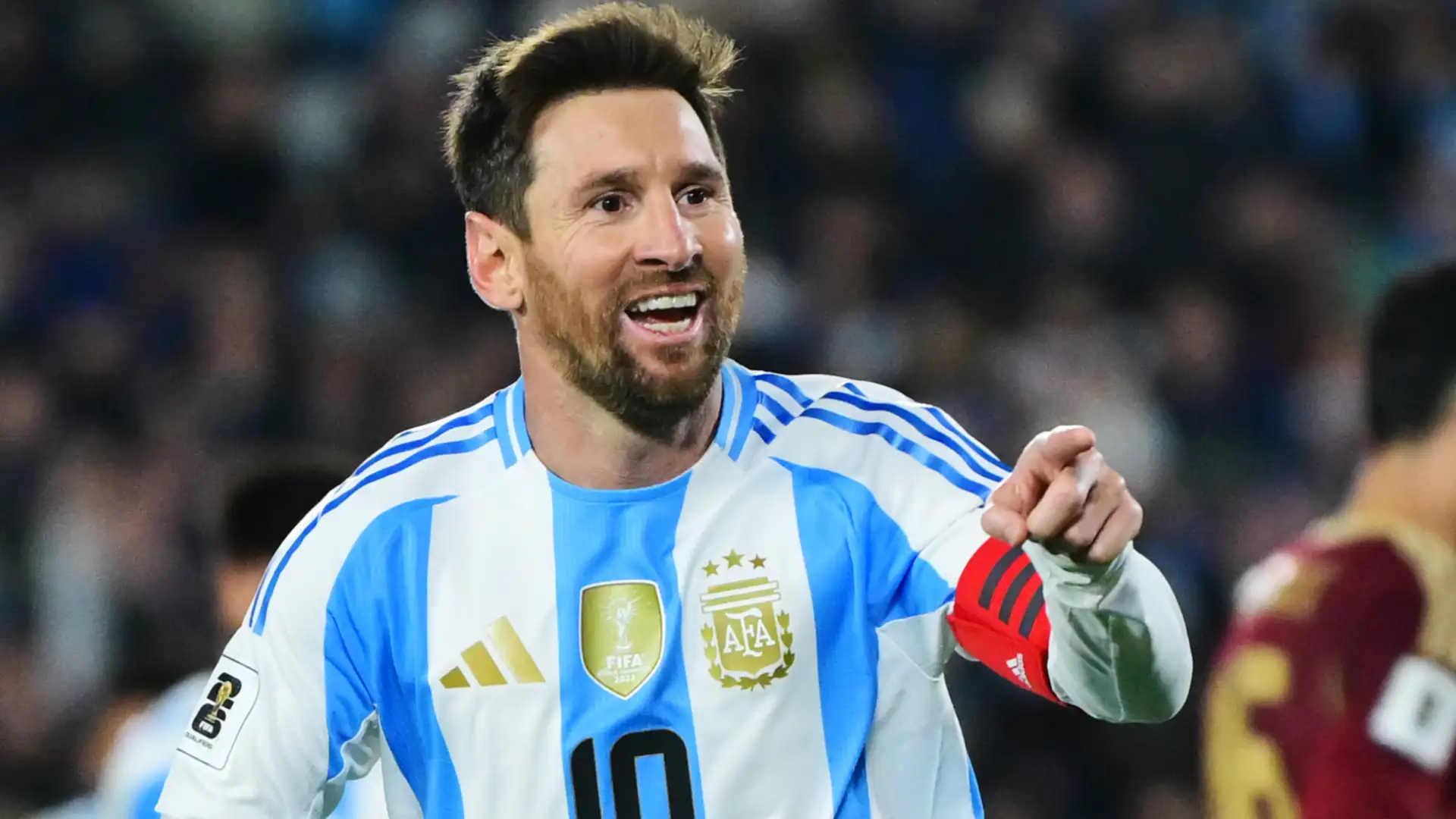 Selebrasi Lionel Messi mengenakan jersey biru-putih Tim Nasional Argentina dengan senyum lebar di bawah lampu stadion