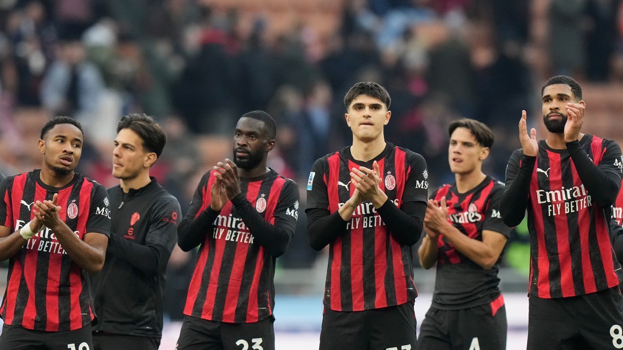 Lima pemain AC Milan memberikan tepuk tangan apresiasi ke arah tribun penonton setelah pertandingan berakhir dengan latar belakang suporter yang buram.