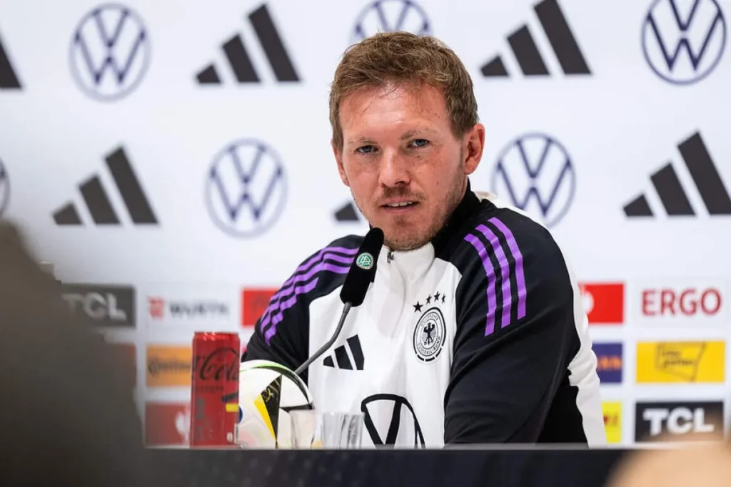 Pelatih Timnas Jerman Julian Nagelsmann dalam sesi konferensi pers dengan latar belakang logo sponsor timnas.