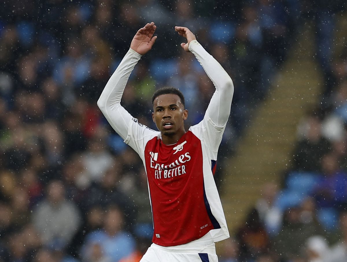 Bek Arsenal, Gabriel Magalhaes, memberi isyarat dengan mengangkat kedua tangan ke arah penonton dalam sebuah pertandingan. Foto ini mengilustrasikan berita mengenai Gabriel yang terpaksa mundur dari skuad timnas Brasil untuk FIFA Matchday Maret 2026 karena cedera lutut kanan.