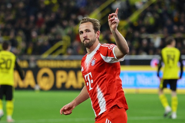 Harry Kane dari Bayern Munchen menunjuk ke langit merayakan gol dalam pertandingan tandang melawan Borussia Dortmund di Bundesliga.