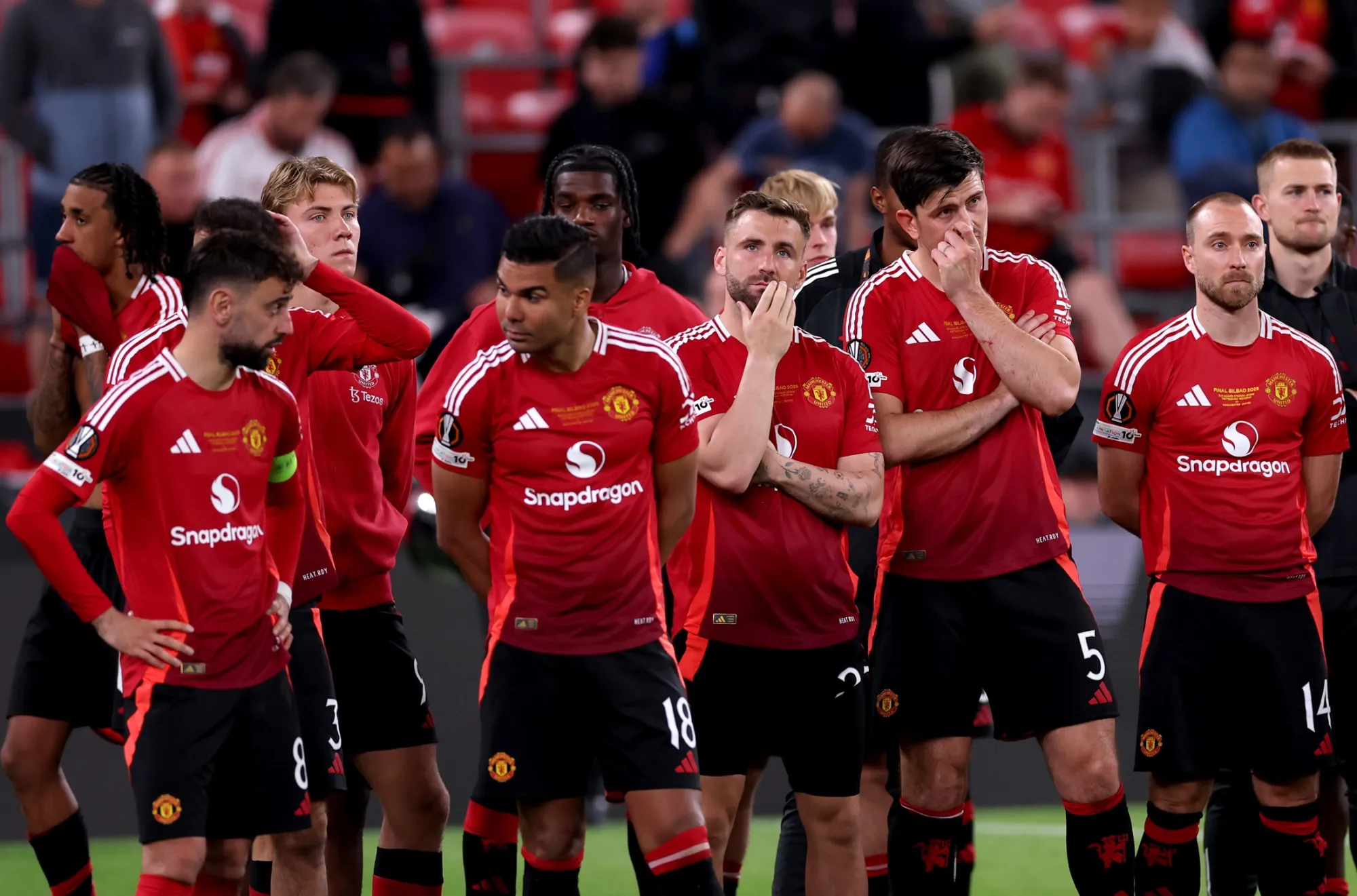 Barisan pemain Manchester United berdiri bersama di lapangan mengenakan jersei merah.