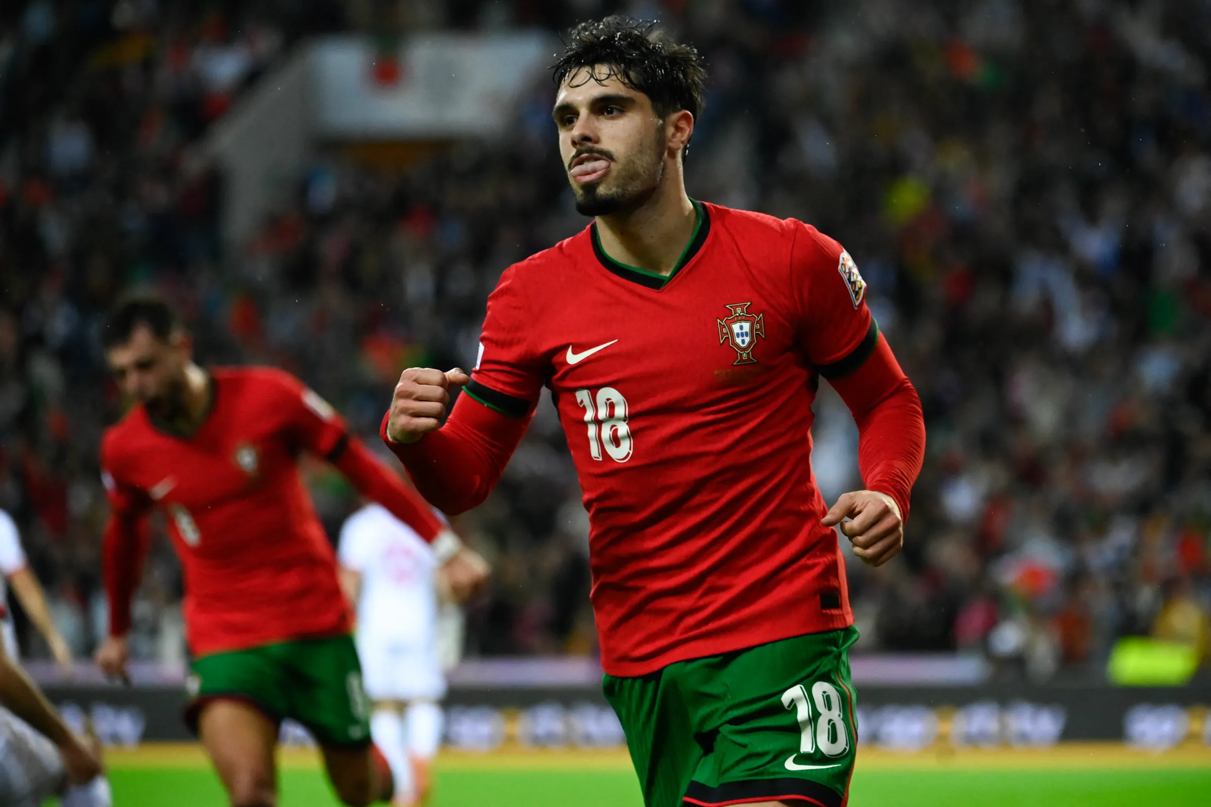 Pedro Neto mengenakan seragam timnas Portugal sedang melakukan selebrasi di lapangan dalam pertandingan internasional.