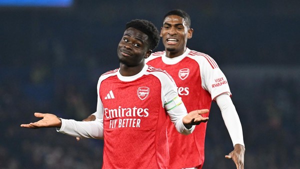Bukayo Saka mengangkat tangan dengan ekspresi bingung dan William Saliba di belakangnya saat pertandingan Arsenal