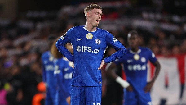 Foto pemain Chelsea (termasuk Cole Palmer dan Moises Caicedo) berdiri di lapangan dengan ekspresi kecewa.