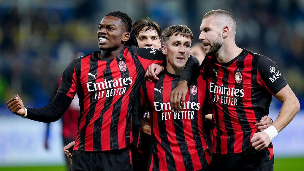 Pemain AC Milan berangkulan merayakan kemenangan di lapangan hijau