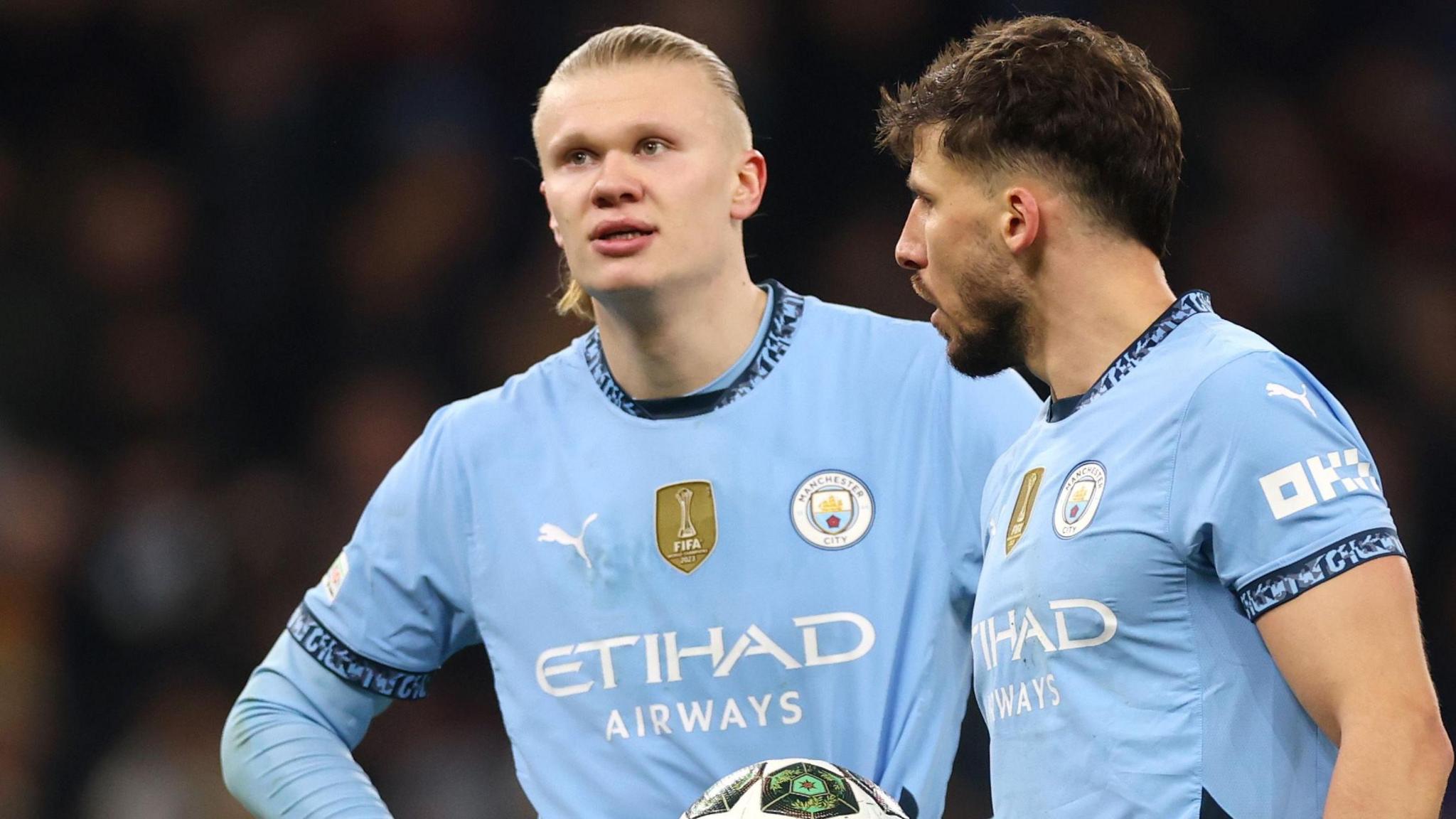 Erling Haaland dan Josko Gvardiol berbincang di tengah pertandingan Manchester City dengan mengenakan jersey biru muda.