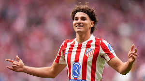 Penyerang Atletico Madrid Julian Alvarez tersenyum saat bertanding di lapangan sepak bola, ilustrasi rumor transfer ke Barcelona.