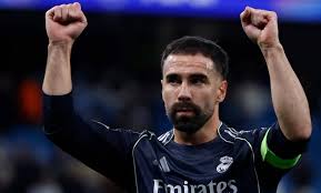Dani Carvajal mengenakan jersey Real Madrid dengan ekspresi serius di lapangan.
