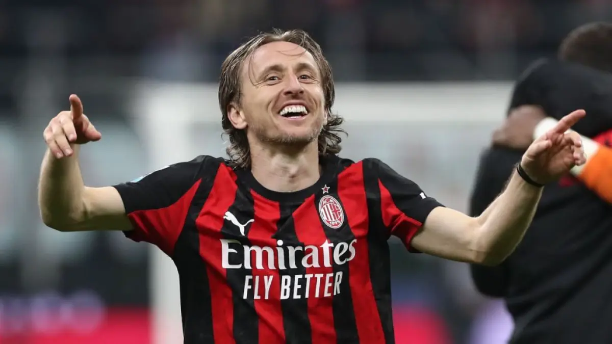 Luka Modric tersenyum lebar sambil mengangkat kedua tangannya merayakan kemenangan AC Milan.