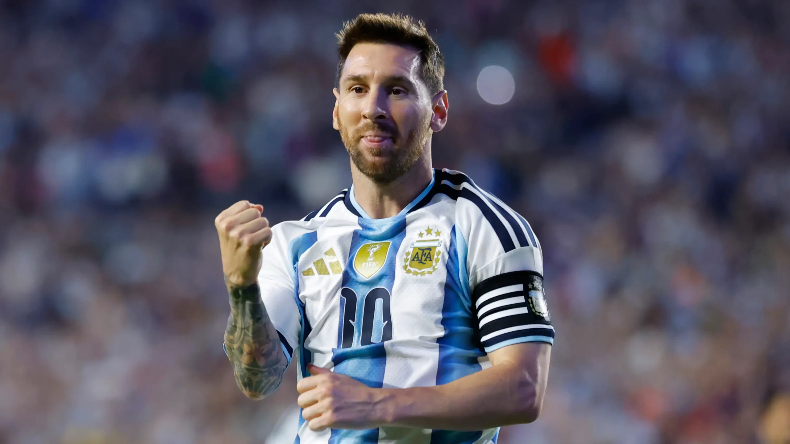 Lionel Messi mengepalkan tangan merayakan gol dengan jersi Argentina.