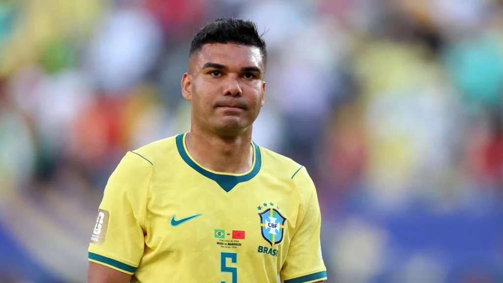 Gelandang bertahan Brasil Casemiro mengenakan jersi tim nasional Brasil tersenyum di lapangan