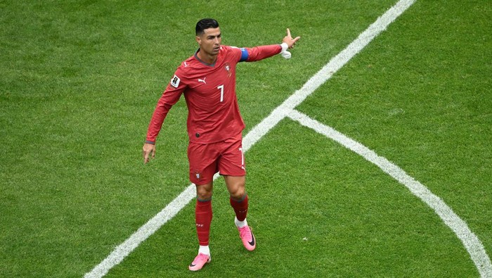Cristiano Ronaldo merentangkan tangan dan memberikan instruksi di lapangan dalam pertandingan timnas Portugal.