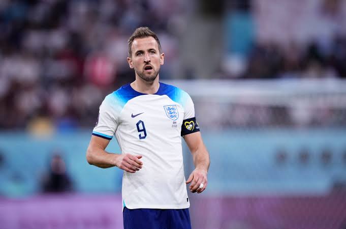 Harry Kane mengepalkan tangan dengan ekspresi fokus dan penuh determinasi saat membela Timnas Inggris.