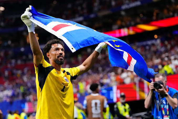 Pemain Cape Verde membentangkan bendera negaranya saat merayakan kelolosan bersejarah ke babak gugur Piala Dunia 2026.