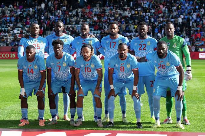 Foto skuad tim nasional sepak bola RD Kongo berseragam biru muda di lapangan menjelang pertandingan Piala Dunia 2026.