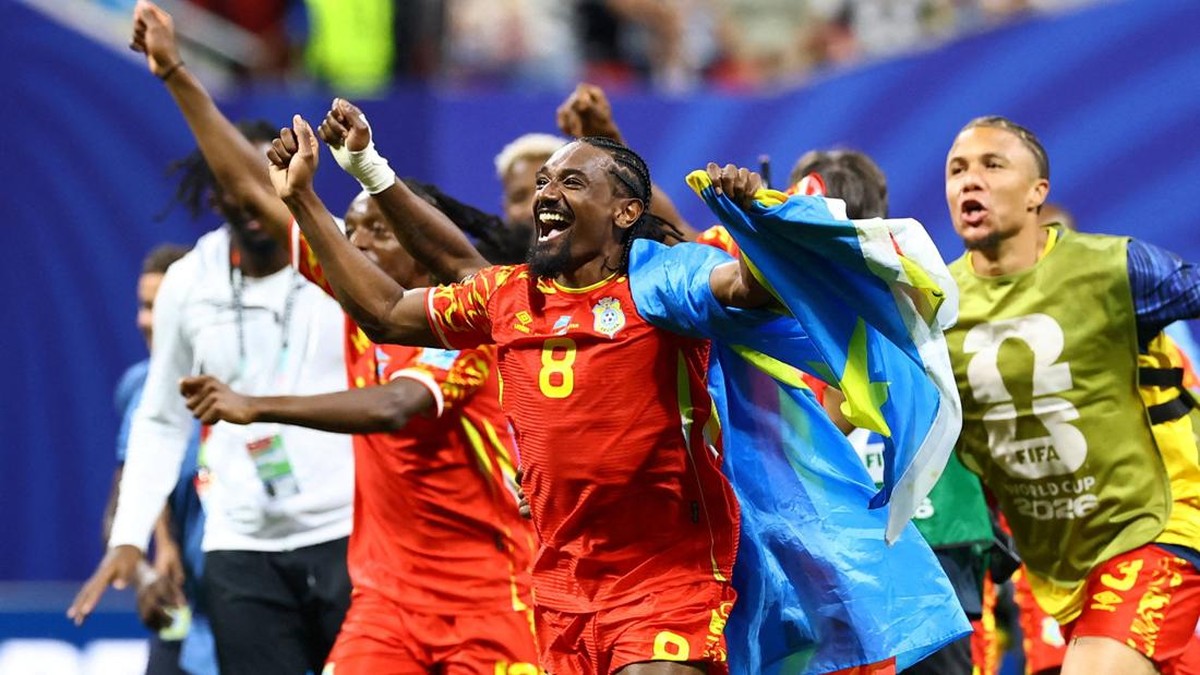 Selebrasi gol emosional para pemain tim nasional sepak bola RD Kongo dengan seragam merah-kuning di lapangan.