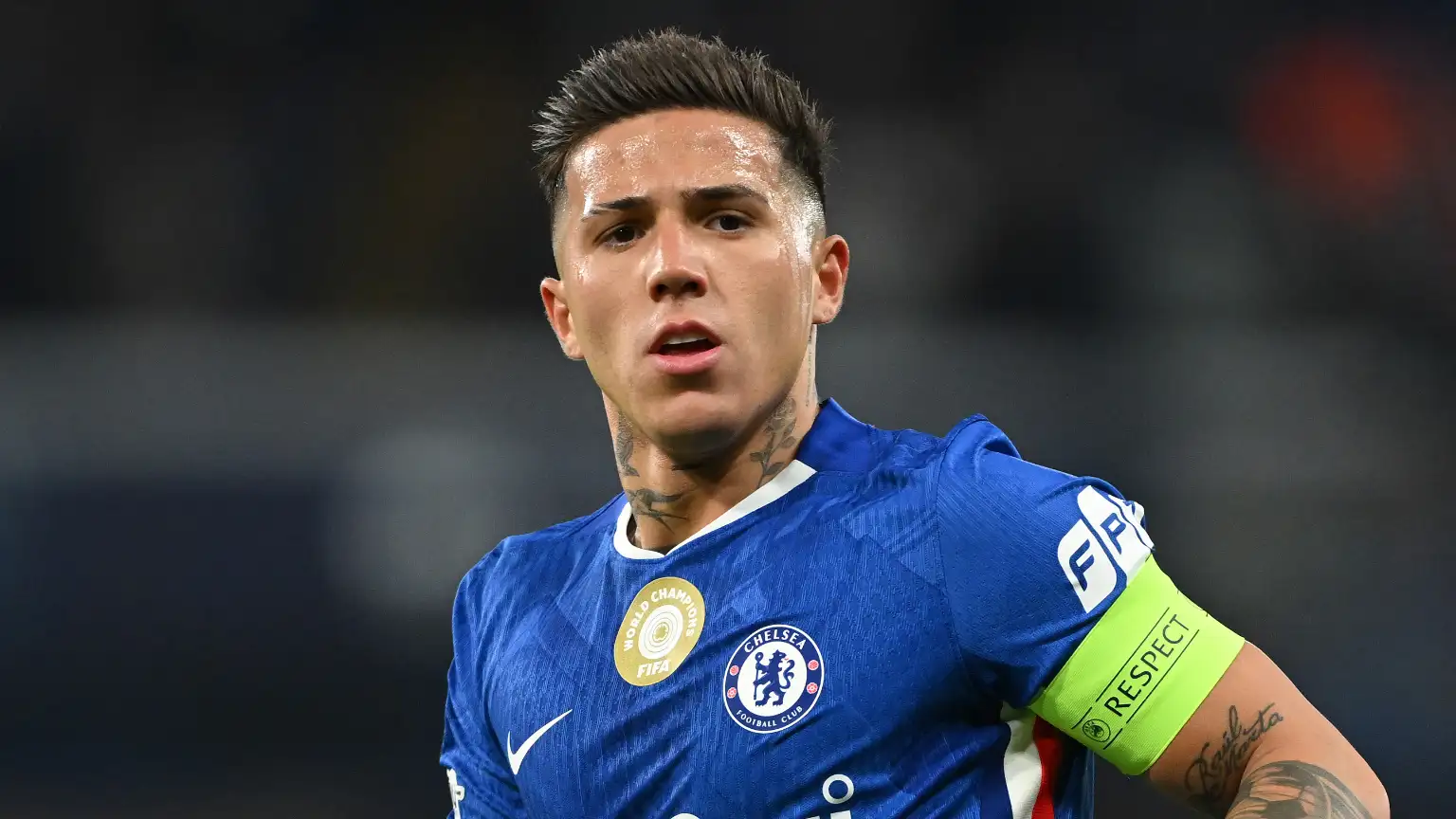 Gelandang Chelsea Enzo Fernandez mengenakan jersey biru dan ban kapten saat bertanding di lapangan.