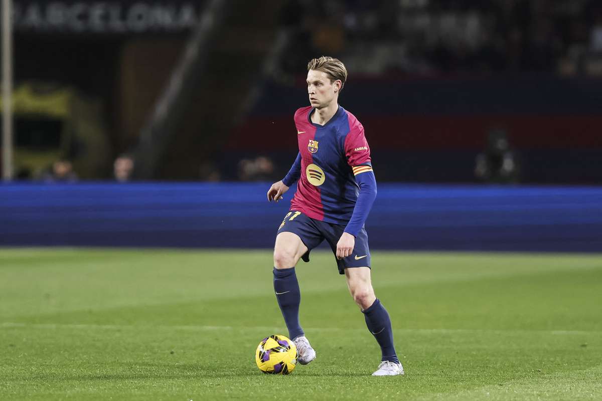 Frenkie de Jong menguasai bola di lapangan dalam seragam Barcelona.