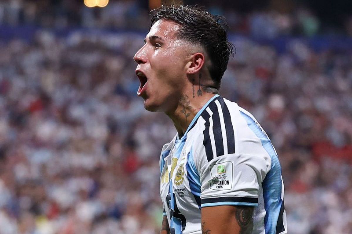 Enzo Fernandez dalam seragam tim nasional Argentina, berteriak kegirangan di lapangan.