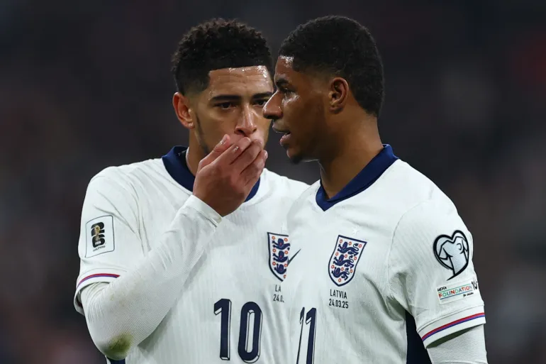 Jude Bellingham dan Marcus Rashford berbincang di lapangan mengenakan jersey Timnas Inggris