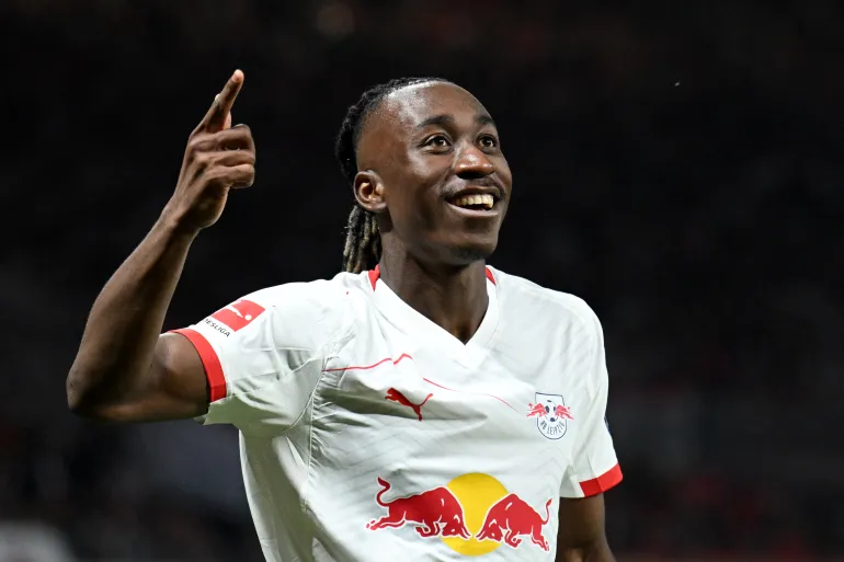 Yan Diomande tersenyum sambil mengacungkan jari telunjuk saat merayakan gol bersama RB Leipzig.