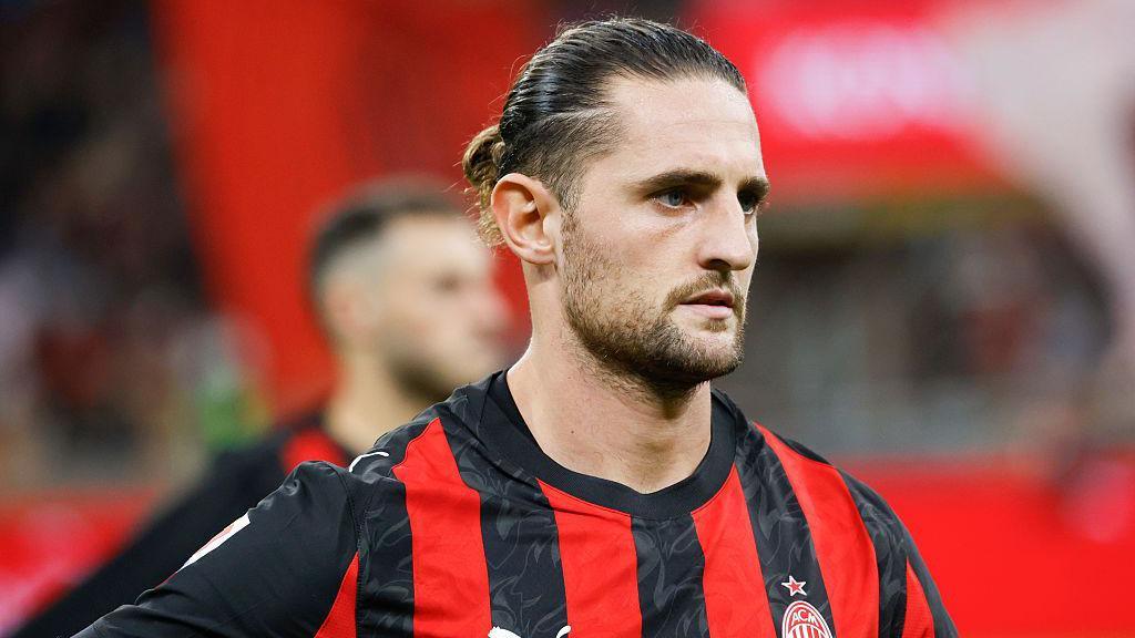 Gelandang AC Milan Adrien Rabiot mengenakan jersey merah hitam Rossoneri di lapangan.