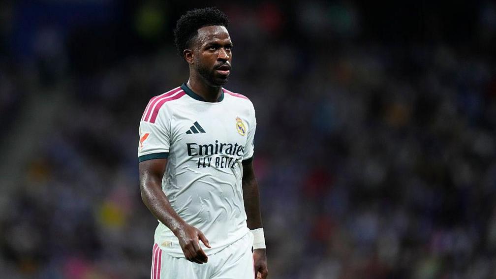 Vinicius Junior mengenakan jersey Real Madrid di lapangan pertandingan