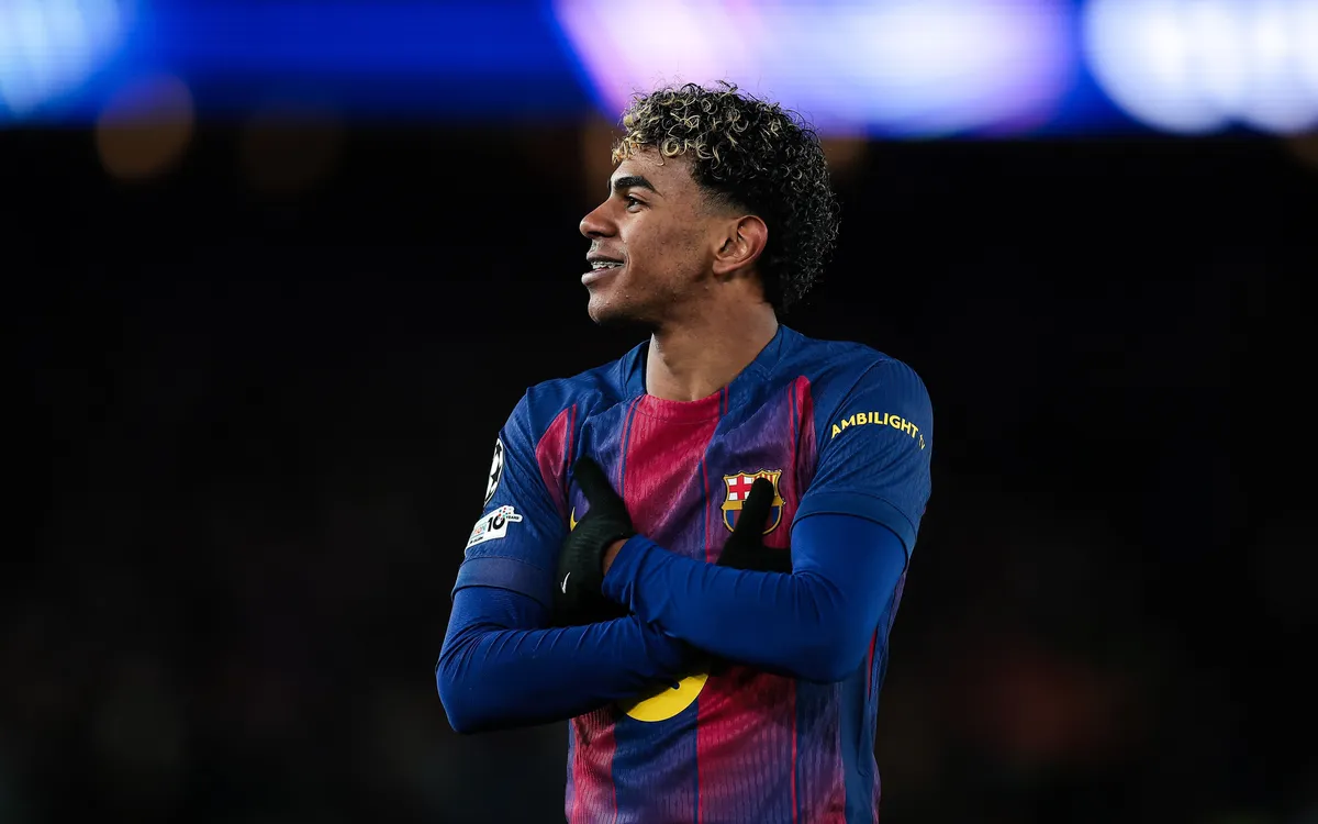 Lamine Yamal mengenakan jersi Barcelona sedang berada di lapangan pertandingan.