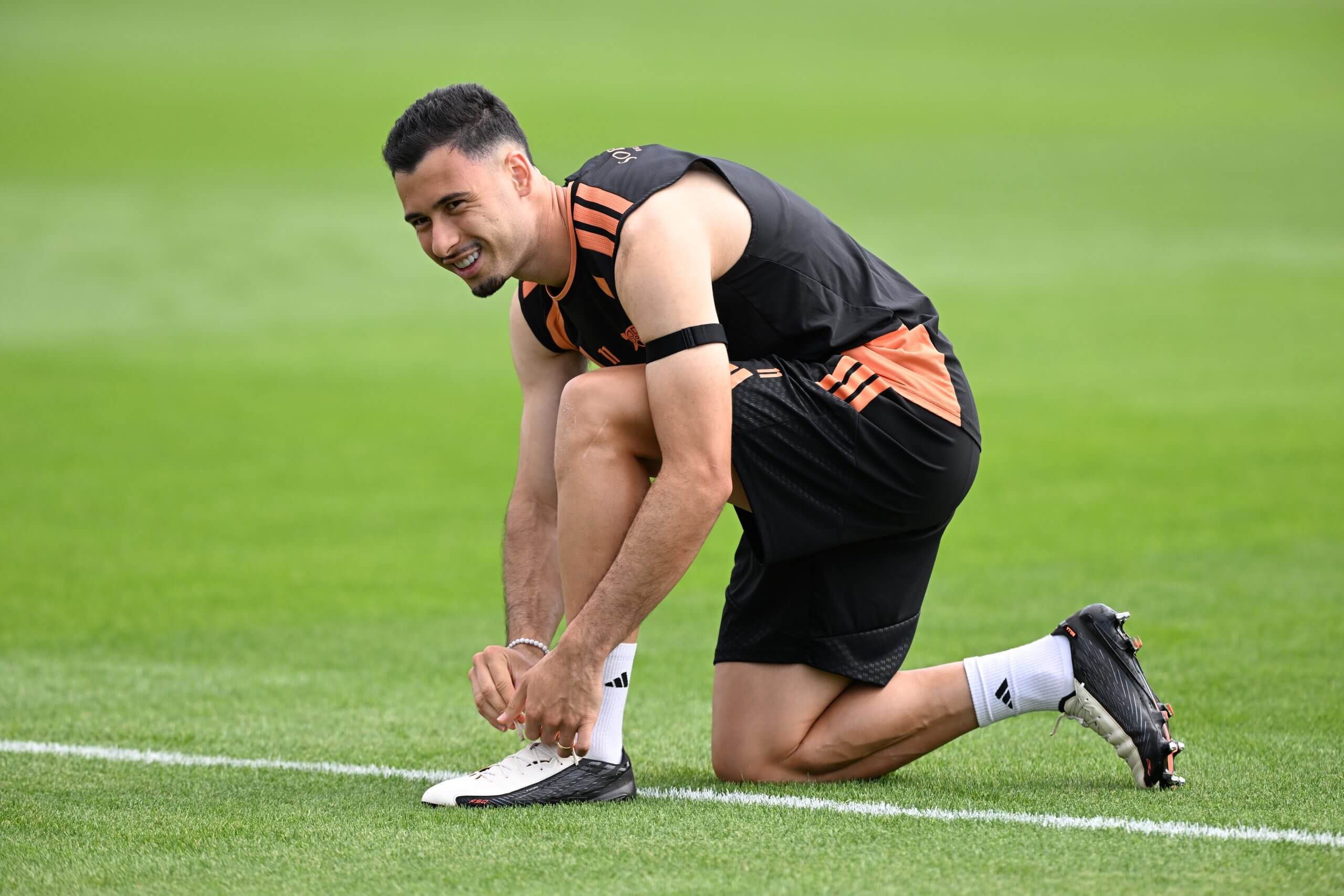 Gabriel Martinelli berlutut mengikat tali sepatu saat sesi latihan Arsenal.