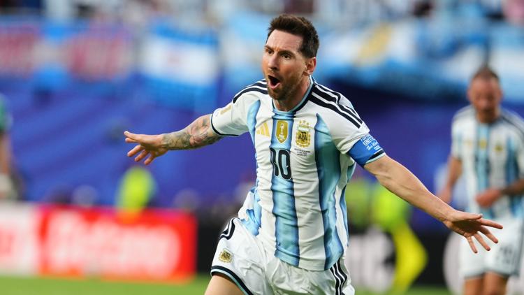 Lionel Messi berlari merayakan gol dengan merentangkan kedua tangannya dalam balutan jersi Timnas Argentina