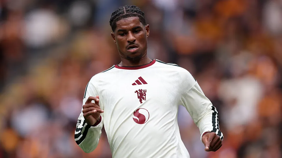 Marcus Rashford berlari di lapangan mengenakan jersey Manchester United
