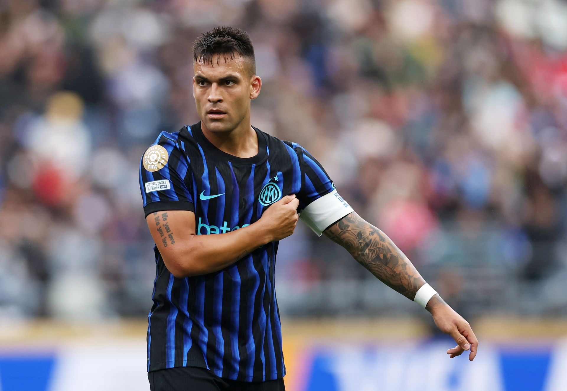 Lautaro Martinez mengenakan seragam Inter Milan dengan ban kapten di lengan saat berlaga di lapangan.