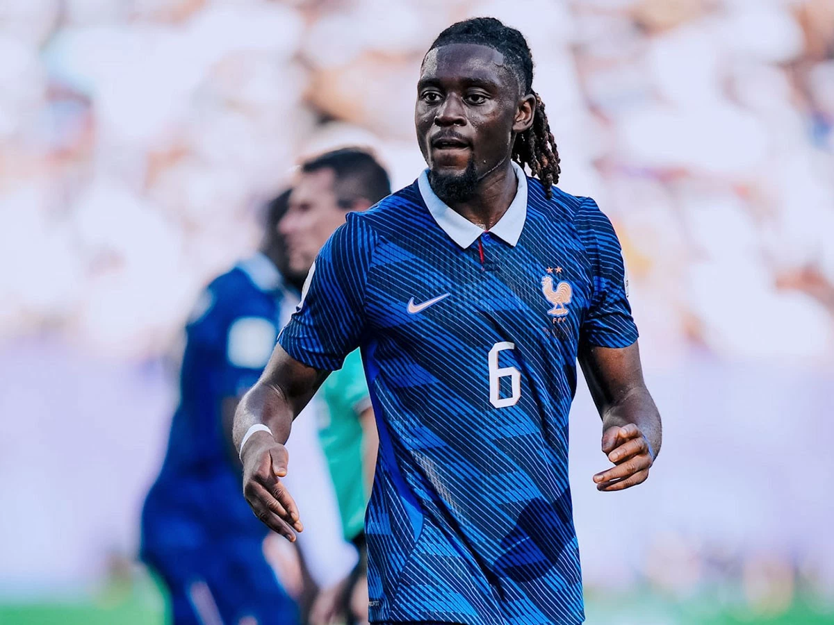 Manu Kone mengenakan jersey tim nasional Prancis bernomor punggung 6 di lapangan.