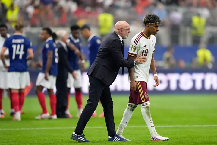 Pelatih Timnas Spanyol Luis de la Fuente merangkul Lamine Yamal di pinggir lapangan saat pertandingan.