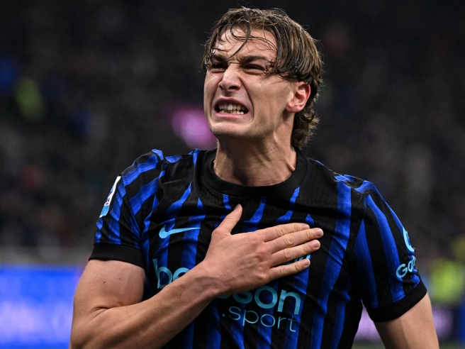 Penyerang Inter Milan Francesco Pio Esposito memegang lambang klub di dada saat merayakan gol.